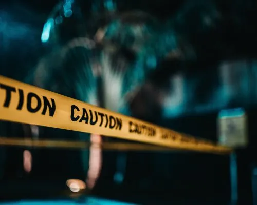 Yellow caution tape stretched across a blurred dark background.