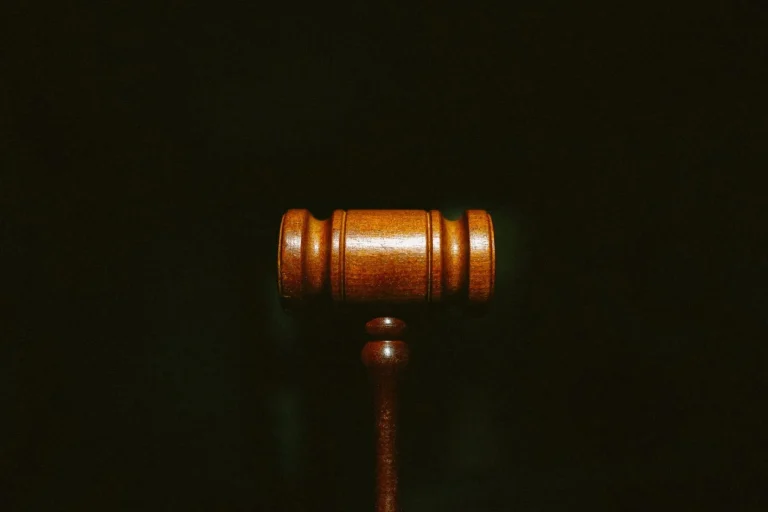 A wooden gavel on a dark background.
